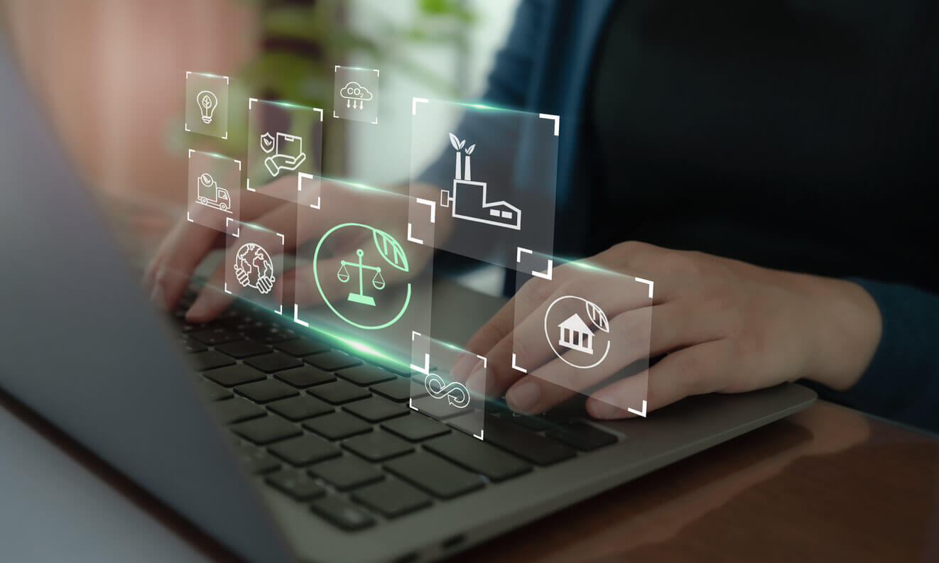 Pessoa digitando em notebook com ícones digitais representando práticas sustentáveis, sociais e de governança, simbolizando a implementação do ESG nas empresas.