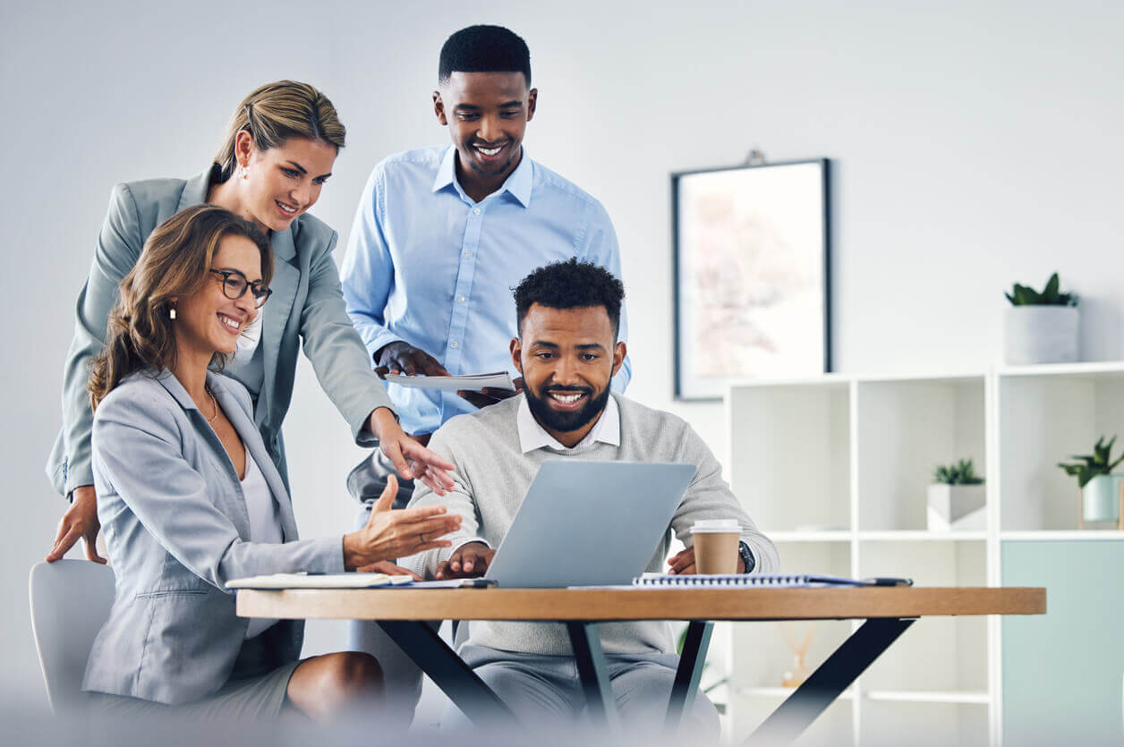 Equipe reunida em ambiente corporativo trocando ideias e sorrisos, representando a importância do RH no fortalecimento da cultura de segurança no trabalho.