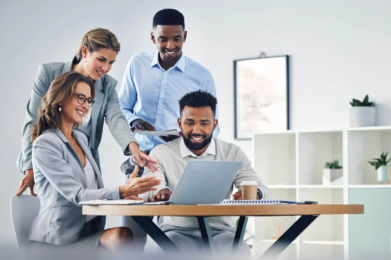 Equipe reunida em ambiente corporativo trocando ideias e sorrisos, representando a importância do RH no fortalecimento da cultura de segurança no trabalho.