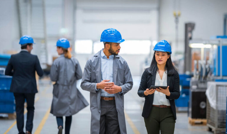 Profissionais do RH e do SESMT inspecionando o ambiente industrial com EPI, representando a aplicação da nova NR-1 nas rotinas de segurança do trabalho.