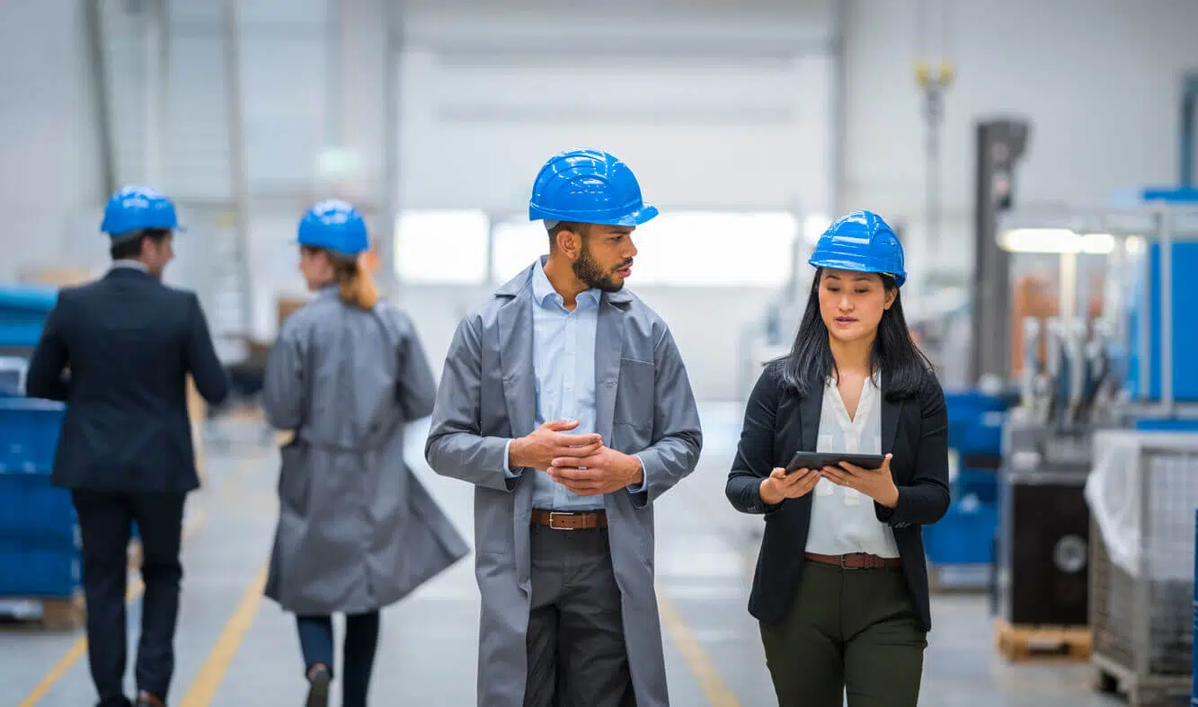 Profissionais do RH e do SESMT inspecionando o ambiente industrial com EPI, representando a aplicação da nova NR-1 nas rotinas de segurança do trabalho.