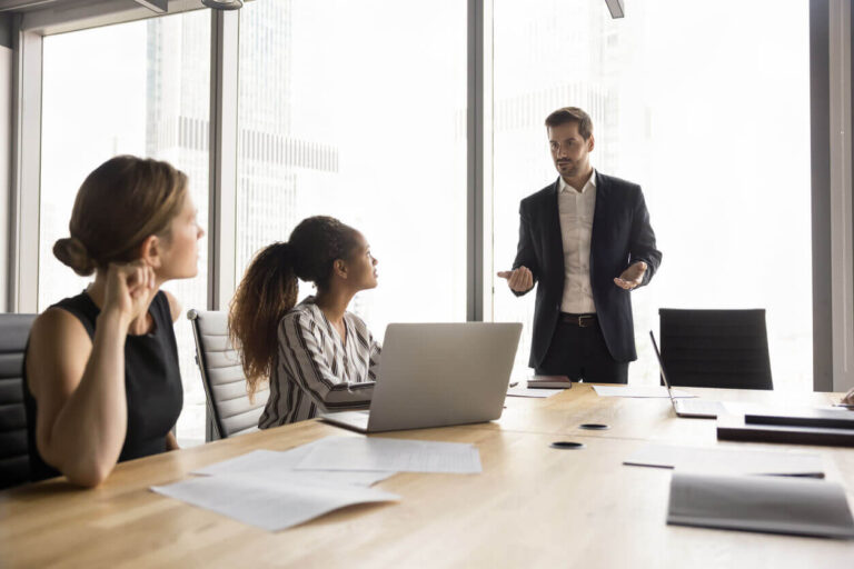 Profissional em reunião com equipe explicando orientações sobre o cumprimento da NR 1 e a importância da conformidade nas normas de segurança do trabalho