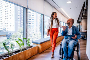 Colaboradores em interação no escritório demonstrando inclusão de PCDs no trabalho, promovendo acessibilidade e diversidade nas empresas