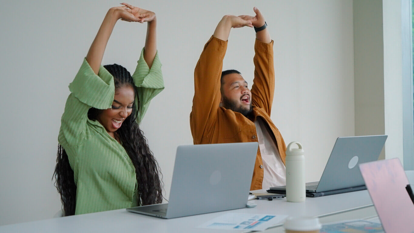 Colaboradores fazendo alongamento no escritório como parte da prática de exercícios no trabalho, promovendo saúde e bem-estar durante a rotina