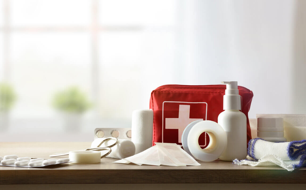 Kit de primeiros socorros nas empresas com bolsa vermelha e materiais básicos de atendimento emergencial