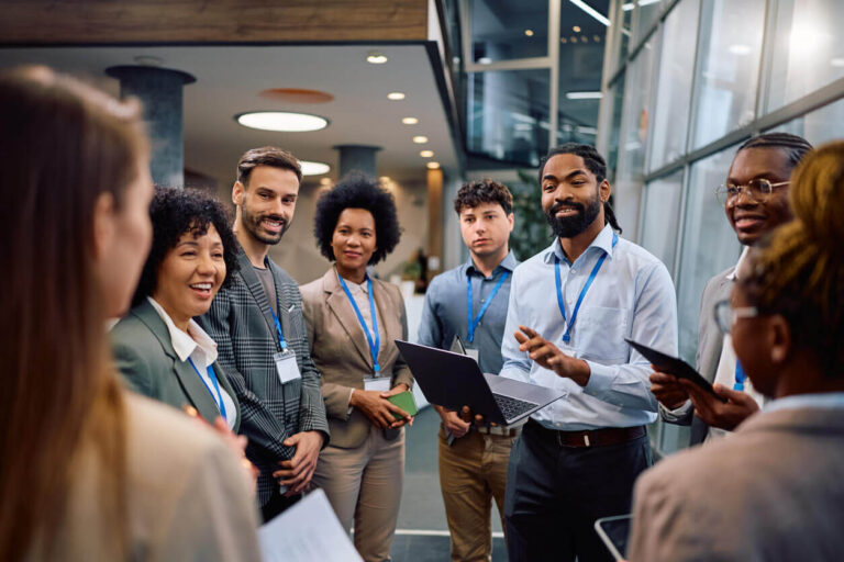 "Profissionais reunidos em ambiente corporativo participando de treinamentos com uso de tecnologia, representando a aplicação de treinamentos corporativos modernos