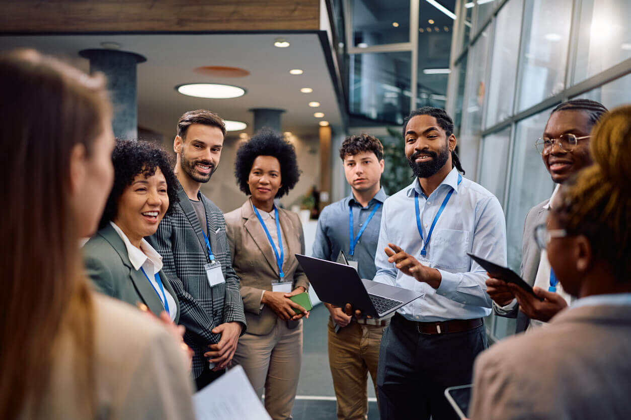 "Profissionais reunidos em ambiente corporativo participando de treinamentos com uso de tecnologia, representando a aplicação de treinamentos corporativos modernos