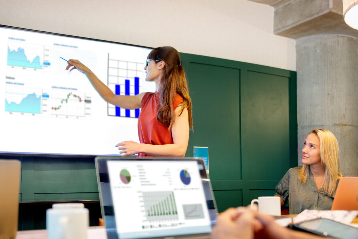 Profissional apresentando gráficos em uma reunião corporativa, ilustrando o uso de dados estratégicos para promover o bem-estar na empresa e melhorar a saúde e produtividade dos colaboradores.