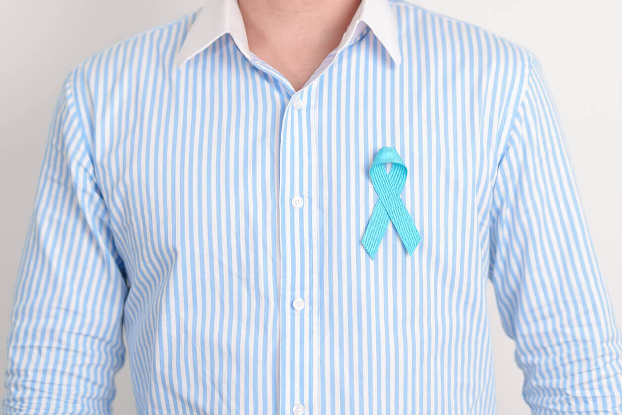 Homem vestindo camisa social azul com laço da campanha preso ao peito, simbolizando o Novembro Azul e a importância da conscientização sobre a saúde masculina e a prevenção do câncer de próstata.