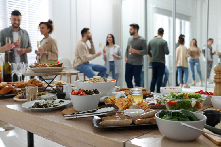 Mesa de buffet em festa de confraternização corporativa com uma variedade de pratos, incluindo saladas frescas e opções mais leves, ilustrando o foco na nutrição nas empresas e no bem-estar dos colaboradores.
